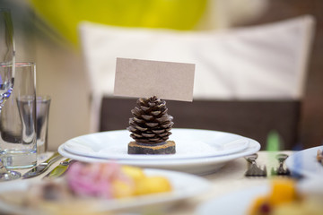 Christmas pinecone on the table with a sign. 