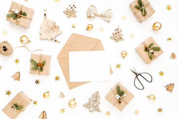 Styled desk with envelope, blank card, craft boxes and Christmas decorations. Flat lay. Mockup template. View from above