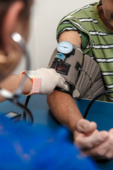 doctor or nurse assessing blood pressure in a patient in an office.