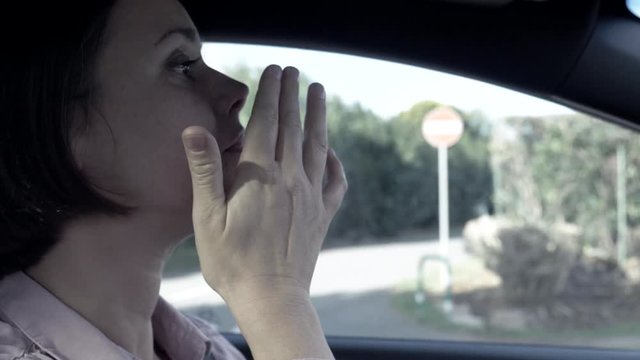 Woman crying while driving car desaturated slow motion