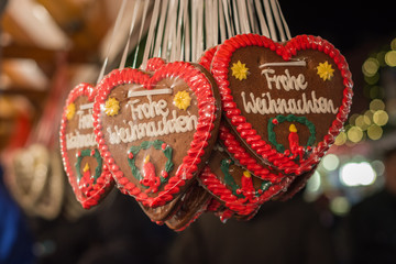 Several gingerbread hearts with Merry Christmas in German at a Christmas market