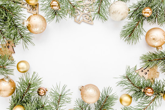 Christmas frame, pattern made in gold colors and and gold glass Christmas balls on white background with empty copy space for text. Holiday and celebration concept. Top view. Flat lay
