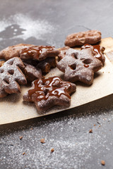 Christmas cookies with powdered sugar on a wooden, cutting board on a gray background