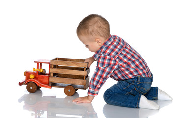 A little boy is playing with a toy car.