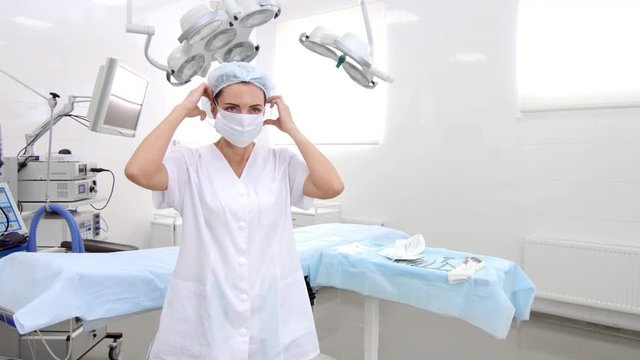 Doctor in white coat put on surgical mask in surgery room