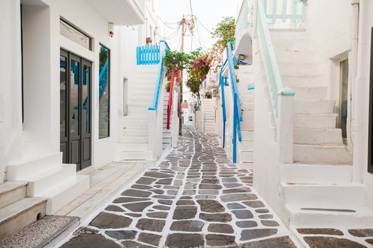 The narrow streets of greek island with cat. Beautiful architecture building exterior with cycladic style. © travnikovstudio
