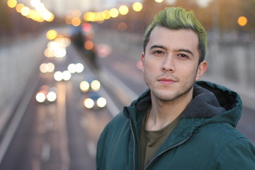 Head shot of handsome green haired guy smiling in the city