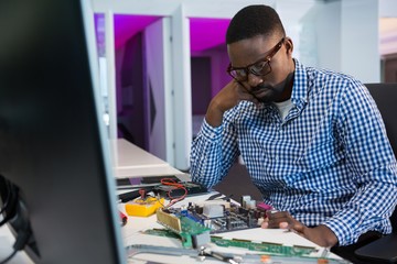 Computer engineer repairing motherboard at desk