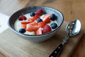 Cream and berries dessert in deep china plate