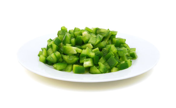 sliced green bell pepper in a plate on white background