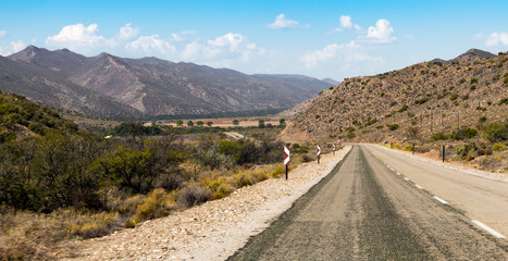 A deserted garden route highway winds through the hills in South Africa