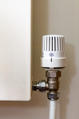 A white radiator TRV temperature control valve set to cold to save central heating energy