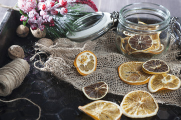 Fototapeta na wymiar the glass jar with dry orange slices with Christmas decorations