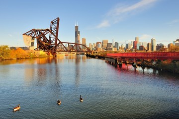 A portion of the Chicago skyline visible beyond the South Branch of the Chicago River and the veneralbe Baltimore & Ohio Chicago Terminal Railroad Bridge (raised) and the St. Charles Airline Bridge.