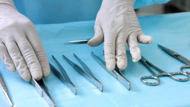 Assistant prepares surgical instruments before surgery
