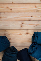 Roll Frayed jeans or blue jeans denim collection on rough wooden table background with copy space, old fashion concept.