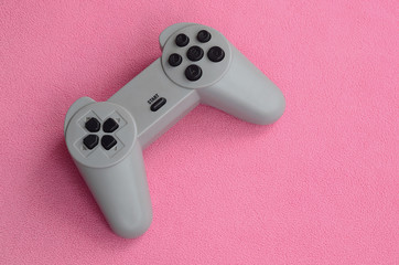 Playing games concept. Single pad joystick lies on the blanket of furry pink fleece fabric....