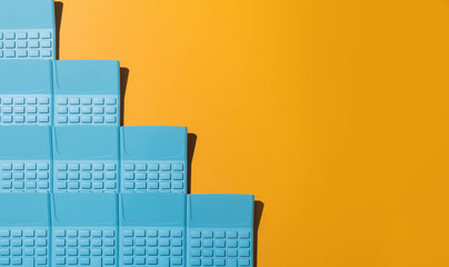 Blue pocket calculators on orange background.