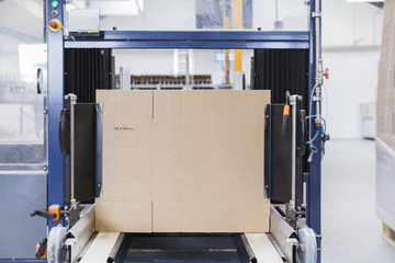 Cardboard being assembled by robot in a factory