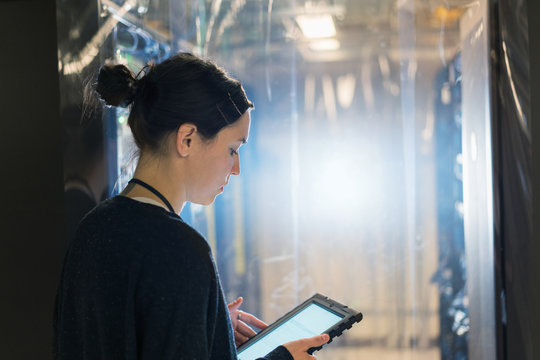 Close up of server room technician looking at digital tablet