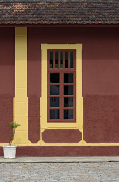 Windows with yellow frame on red wall, in old train station