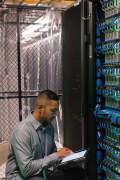 Server room tech sits in front of a server