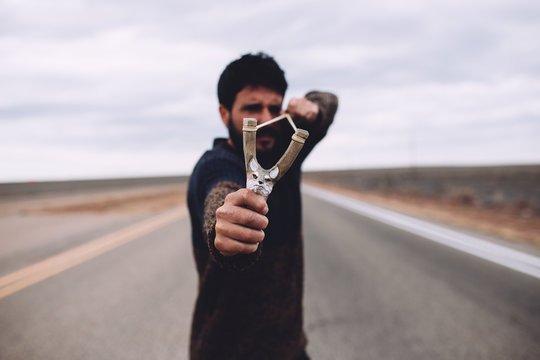 man playing with a slingshot