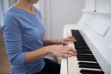 Mid section woman playing piano - Powered by Adobe