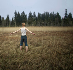 guy standing in field, arms outstretched