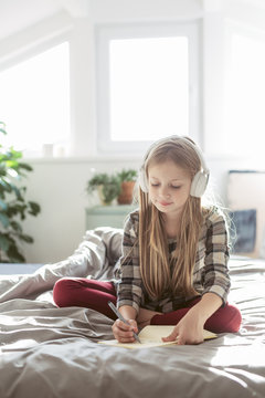 Little Girl With Headphones Writing