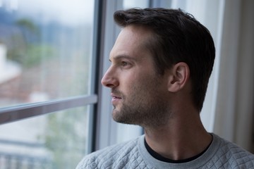Thoughtful man looking through window