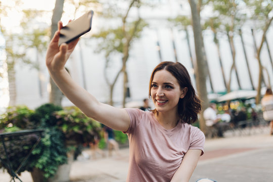 Attractive brunette takes a selfie with the cell phone