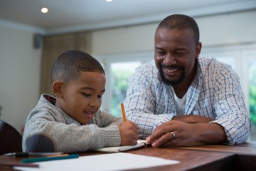 Father helping his son with homework in living room
