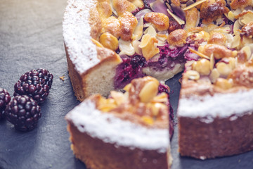 Homemade Christmas or New Year holiday berry pie with nuts on wooden table background. Concept of festive desserts