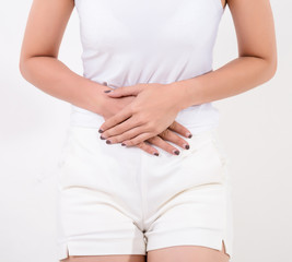 Pain in stomach. Beautiful young Asian woman feeling strong abdominal pain.  Isolated on white background. Studio lighting. Concept for healthy and medical