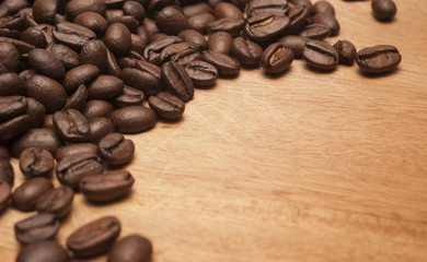 Coffee beans on the wooden board.Close up shot with selective focus.