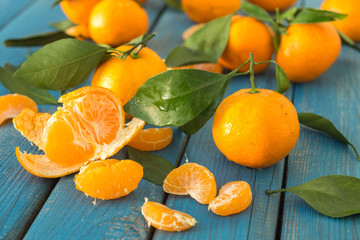 Fresh bright peeled tangerines with green leaves