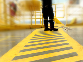Walkway lane in the Offshore Oil rig with worker between parallel yellow lines 