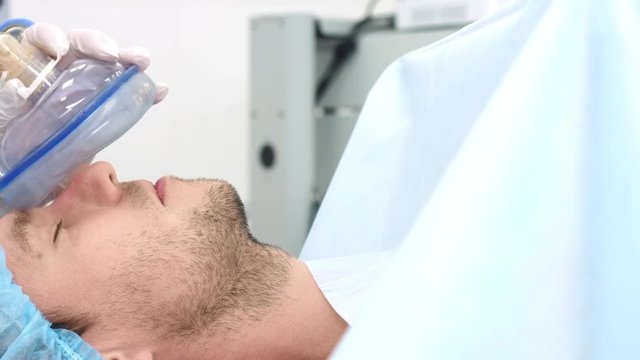Anesthetist putting breathing mask on patient's face