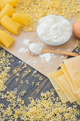 Uncooked raw pasta alphabet yellow letters with macaroni and lasagna