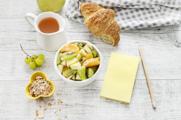 Yellow notebook and healthy food on wooden table