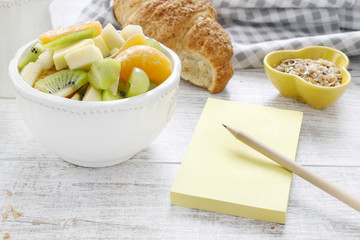 Yellow notebook and healthy food on wooden table