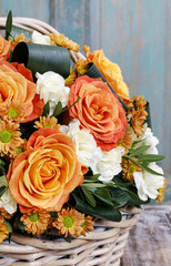 Bouquet of orange roses and ivory carnation flowers.