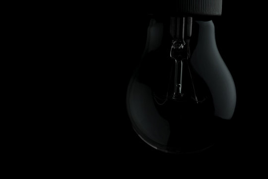 Light bulb on black background with copy text