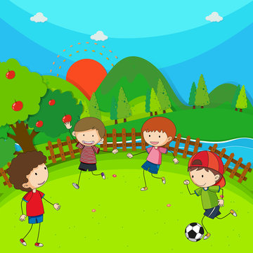 Four children playing football in the park