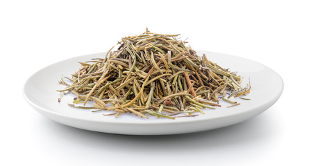 Dried rosemary leaves in a plate isolated on a white background