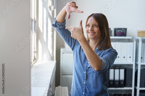 "frau im büro bildet eine rahmen mit den händen" Stockfotos und