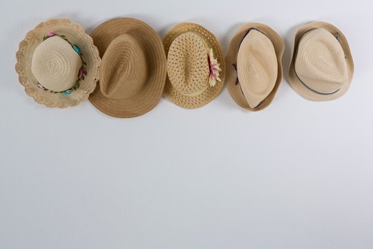 Various straw hats hanging on hook
