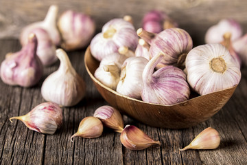 Close-up garlic bulbs and garlic cloves on wooden background