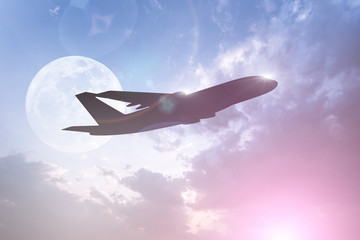 Silhouette of Airplane take off on the Colorful dramatic sky with cloud at full moon background